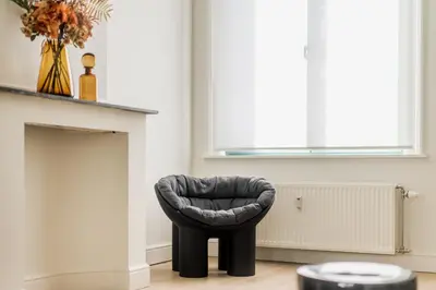a black chair sitting next to a fireplace at Quartier Le Sud in Antwerp