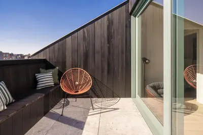 a balcony with a bench and chairs on a building at Quartier Le Sud in Antwerp