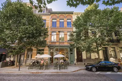 a building with tables and chairs in front of it at Quartier Le Sud in Antwerp