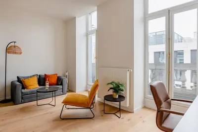 a living room with a couch and two tables at Center Royal Residence in Brussels