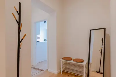 a mirror and stool in a room with a hallway at Center Royal Residence in Brussels