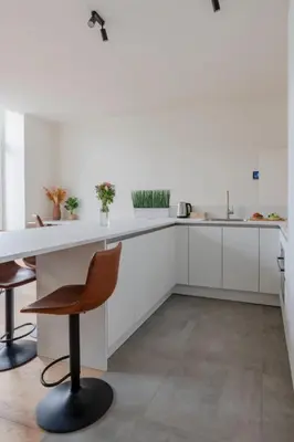 a kitchen with white cabinets and a table and chairs at Center Royal Residence in Brussels