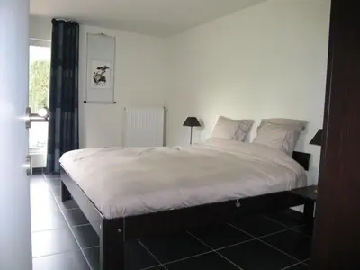 a bedroom with a large bed with white sheets and pillows at Holiday Home and Office Domisi'l in Wachtebeke