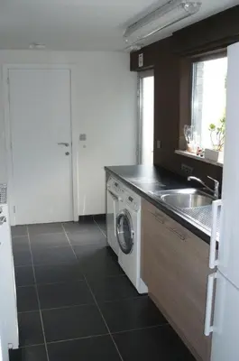 a kitchen with a sink and a washing machine at Holiday Home and Office Domisi'l in Wachtebeke