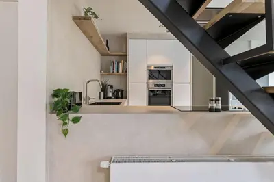 a kitchen with white walls and a black ceiling at Schitterende loft met jacuzzi en sauna in Mechelen in Mechelen