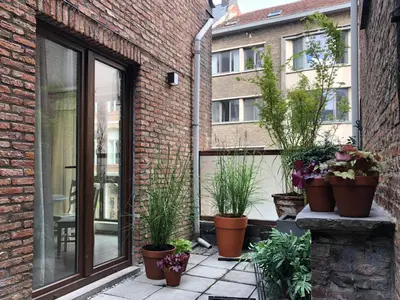 a patio with potted plants on a brick building at Giorgio in Antwerp