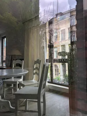 a dining room with a table and chairs and a window at Giorgio in Antwerp