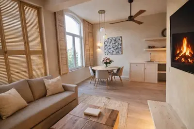 a living room with a couch and a table with a fireplace at Japandi Apartment, Cityview Elevator in Antwerp