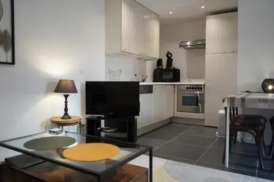 a living room with a table and a television at The Suite Escape Apartment Sand in Sint-Lievens-Houtem
