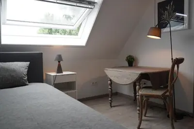 a bedroom with a bed and a desk and a window at The Suite Escape Apartment Sand in Sint-Lievens-Houtem