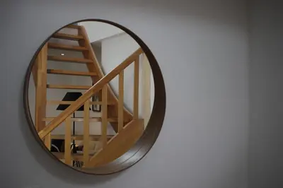 a mirror on a wall with a staircase in it at The Suite Escape Apartment Sand in Sint-Lievens-Houtem