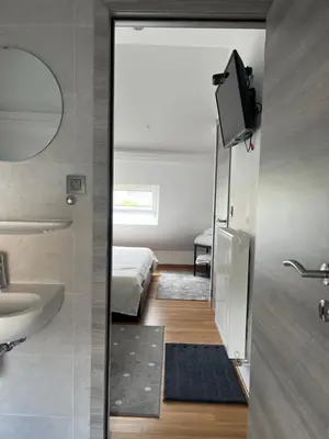 a bathroom with a mirror and a sink and a bed at Au Marolles chambre Atomium in Brussels