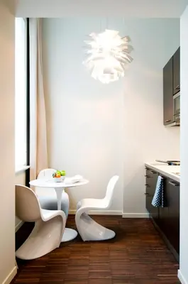 a white table and chairs in a kitchen with a chandelier at Apartment Nyhuset in Brussels
