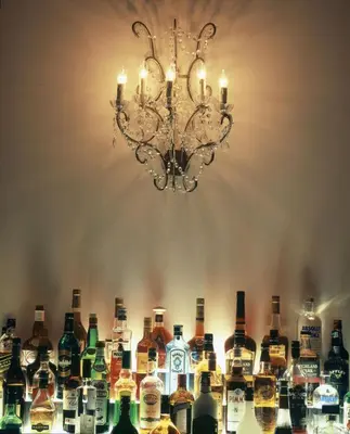 a bunch of bottles of alcohol on a bar with a chandelier at Apartment Nyhuset in Brussels