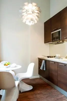 a kitchen with a table and white chairs and a chandelier at Apartment Nyhuset in Brussels