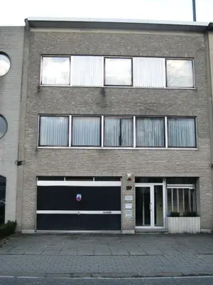 a large brick building with two garage doors at B&B Middelheim in Antwerp