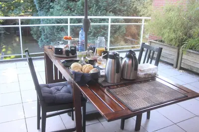 a wooden table with a tea kettle and bread on it at B&B Middelheim in Antwerp