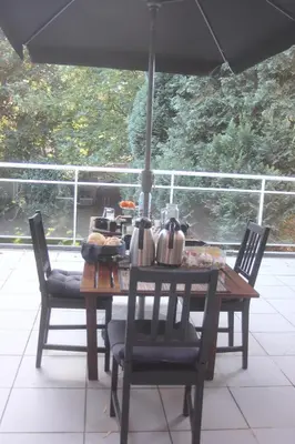 a wooden table with chairs and a table with food on it at B&B Middelheim in Antwerp