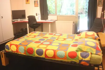 a bedroom with a bed with a colorful blanket at B&B Middelheim in Antwerp