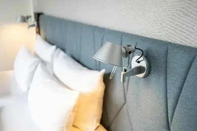 a lamp on a wall next to a bed at Motel One Brussels in Brussels