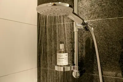 a shower in a bathroom with a bottle of soap at Motel One Brussels in Brussels