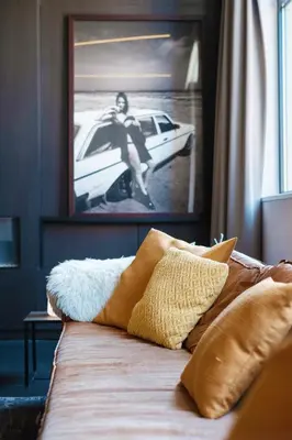 a bed with pillows and a picture of a woman at Hotel Elisabeth in Mechelen