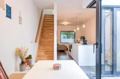 a kitchen and living room with a staircase in a house at Stylishly furnished private home in a vibrant area in Antwerp
