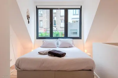 a bed in a room with a large window at Stylishly furnished private home in a vibrant area in Antwerp