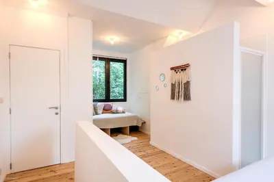 a room with white walls and a hallway with a door at Stylishly furnished private home in a vibrant area in Antwerp
