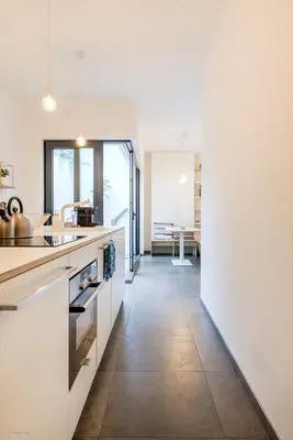 a kitchen with white cabinets and a tile floor at Stylishly furnished private home in a vibrant area in Antwerp