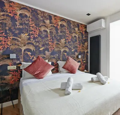 a bedroom with a large bed with a floral wallpaper at Hotel Les Ecrins in Brussels