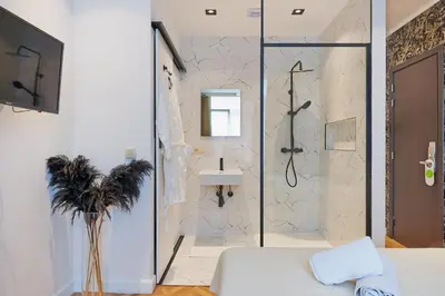 a bathroom with a shower and a sink at Hotel Les Ecrins in Brussels