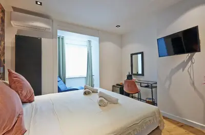 a bedroom with a bed with a tv on the wall at Hotel Les Ecrins in Brussels
