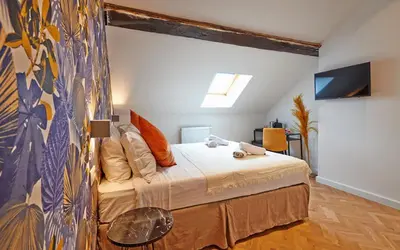 a bedroom with a bed and a tv in it at Hotel Les Ecrins in Brussels