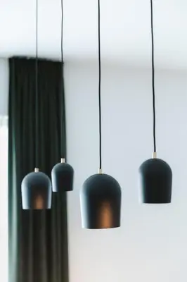 four black pendant lights hanging from a wall at Apartment The City in Ghent