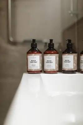 a row of four bottles of soap sitting on a shelf at Apartment The City in Ghent