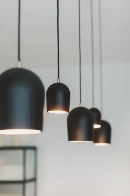 four black pendant lights hanging from a wall at Apartment The City in Ghent