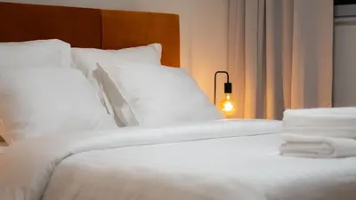 a bed with white sheets and pillows in a room at LUXURY LUMINOUS 2bedroom apt CENTER of BRUSSELS in Brussels