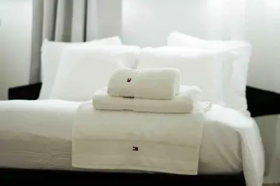 a white bed with white towels on top of it at LUXURY LUMINOUS 2bedroom apt CENTER of BRUSSELS in Brussels