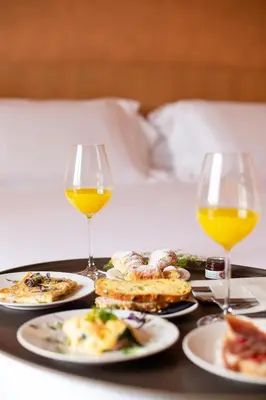a tray with plates of food and two glasses of wine at LUXURY LUMINOUS 2bedroom apt CENTER of BRUSSELS in Brussels