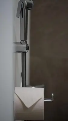 a piece of paper sticking out of a toilet paper dispenser at LUXURY LUMINOUS 2bedroom apt CENTER of BRUSSELS in Brussels