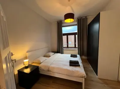 a bedroom with a large bed and a window at Cosy Apartment Merode in Brussels