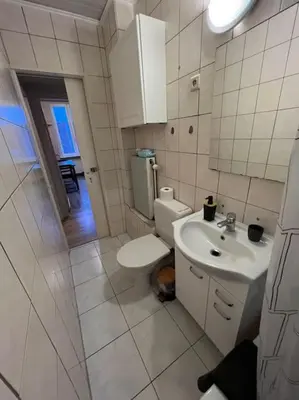 a white bathroom with a toilet and a sink at Cosy Apartment Merode in Brussels
