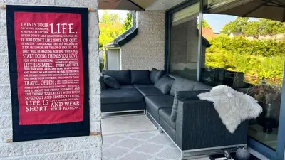 a couch sitting on a porch with a sign at Ikigai B&B - wellness in Oud-Turnhout