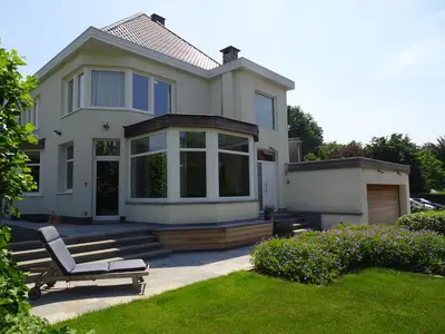 a white house with a bench in the yard at B&B Maaltebrug in Ghent