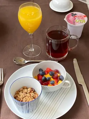 a table with a bowl of cereal and a glass of orange juice at B&B Maaltebrug in Ghent