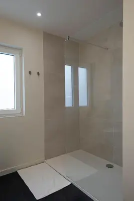 a bathroom with a glass shower with a window at B&B Maaltebrug in Ghent