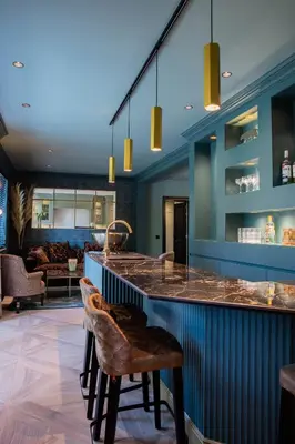 a kitchen with a counter and a bar with chairs at La Garçonnière Genval in Rixensart