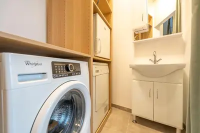 a laundry room with a washing machine and a sink at SHWAY - The Saffron Dress in Antwerp