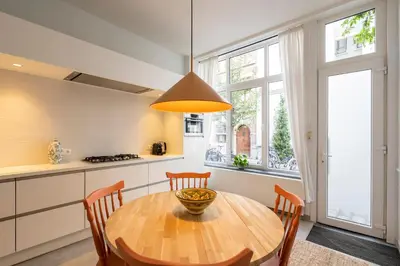 a kitchen with a wooden table and some chairs at SHWAY - The Saffron Dress in Antwerp